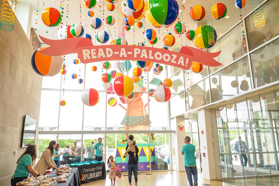 beach ball installation hanging in library lobby, Read-a-palooza sign, staff behind tables